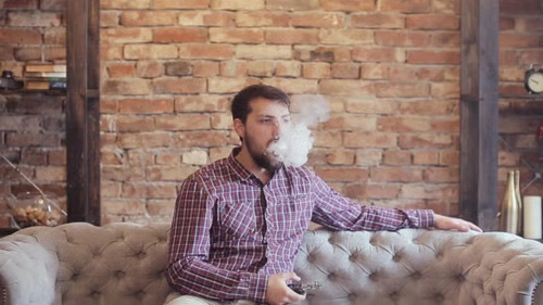 Entspannte Person zu Hause beim Dampfen mit einem 12K Vape aus der Premium Vape Auswahl